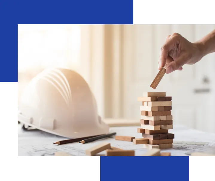 Ułożone drewniane klocki obok kasku budowlańca